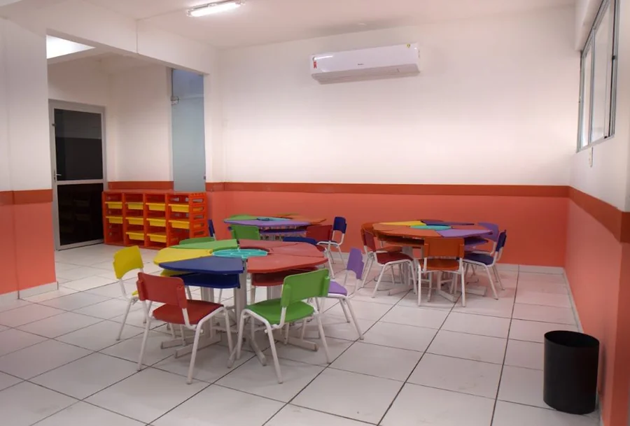 Sala de aula colorida do Contemporâneo com mesas redondas e cadeiras coloridas