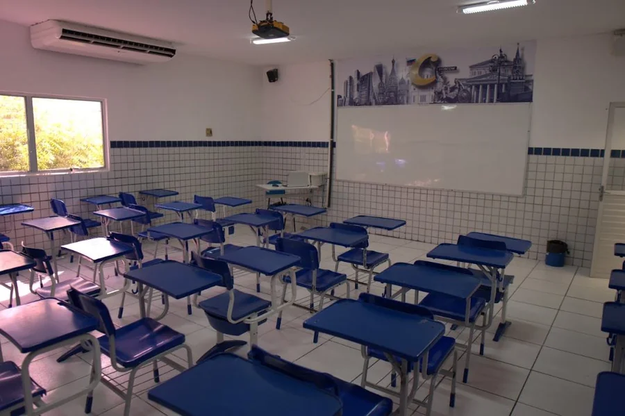 Sala de aula do Contemporâneo com carteiras azuis e lousa