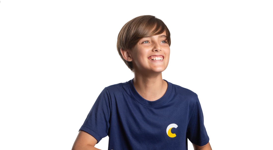 Aluno do Contemporâneo sorrindo, apoiado em uma mureta, com fundo azul-marinho e grafismo de sol